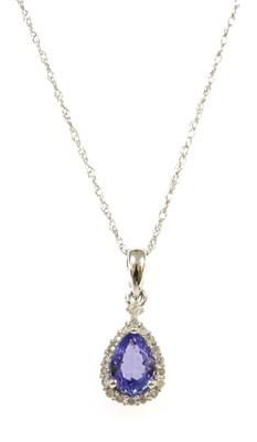 Lot 310 - A white gold tanzanite and diamond halo cluster pendant