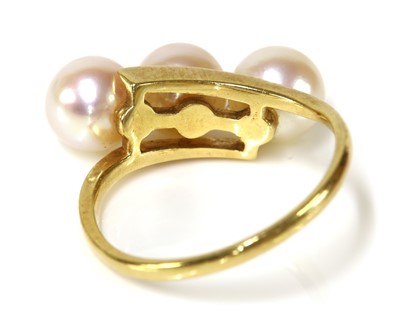 Lot 307 - A three stone cultured pearl crossover ring, by Mikimoto