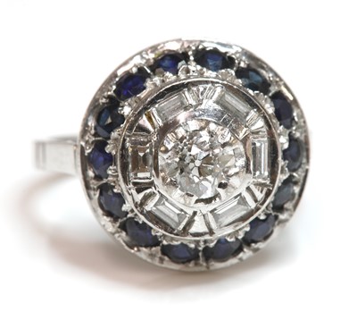 Lot 261 - A white gold diamond and sapphire circular stepped cluster ring