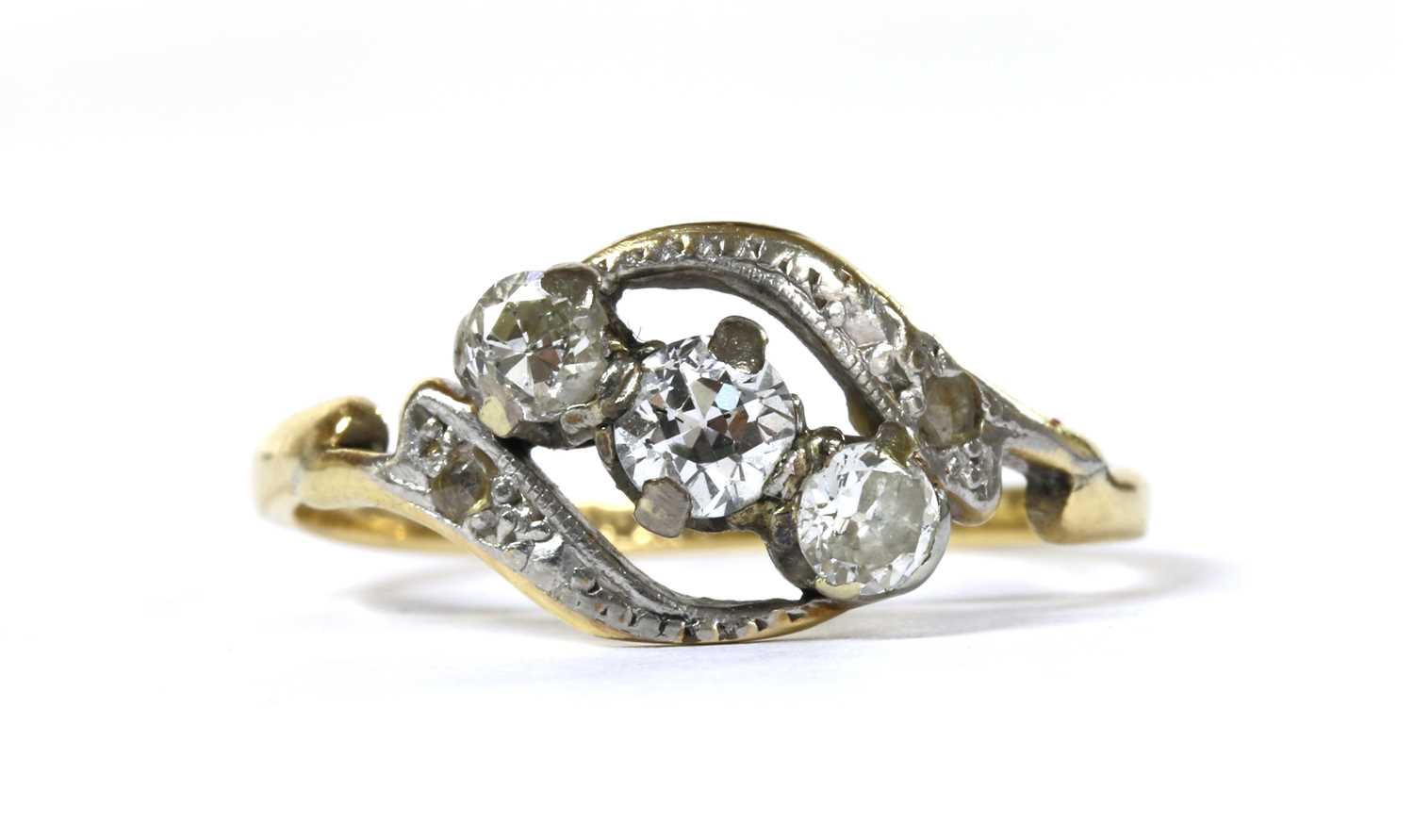 Lot 94 - A gold three stone diamond crossover ring