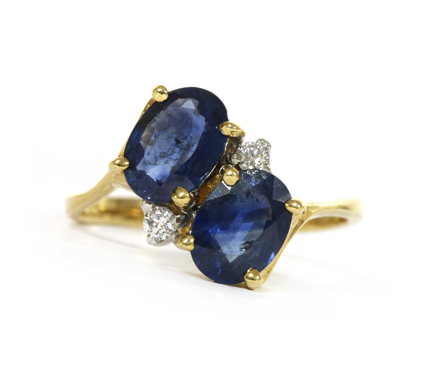 Lot 1221 - An 18ct gold sapphire and diamond crossover ring