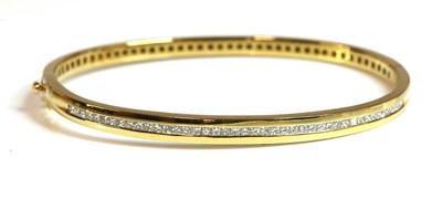 Lot 394 - An 18ct gold graduated diamond set oval hinged bangle