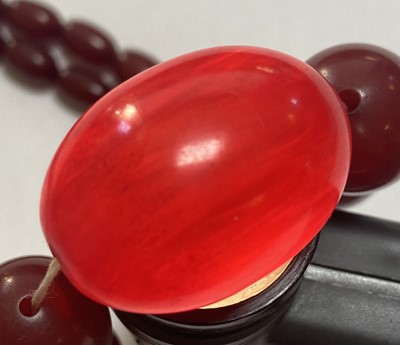 Lot 68 - A single row graduated cherry coloured Bakelite bead necklace