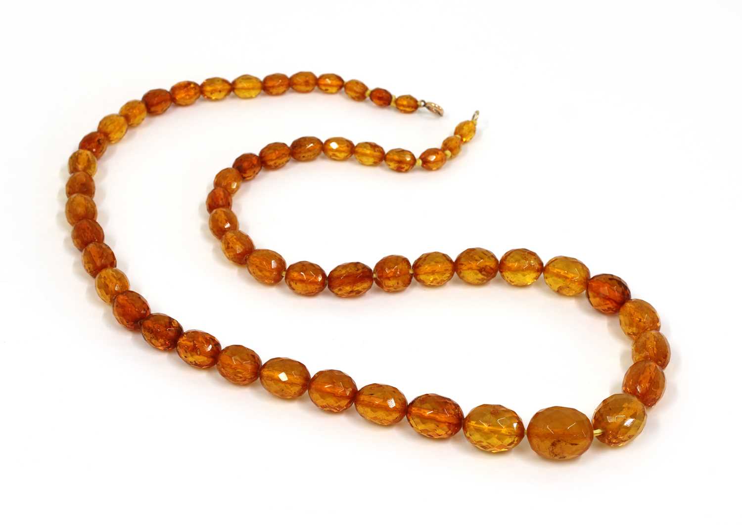 Lot 64 - A single row graduated faceted cognac amber bead necklace
