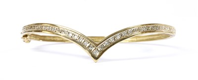 Lot 1109 - A 9ct gold diamond wishbone bangle