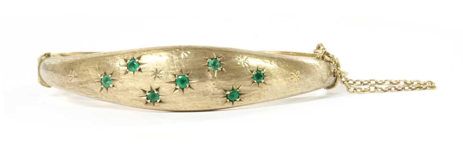 Lot 1071 - A 9ct gold emerald hinged bangle, by Smith & Pepper