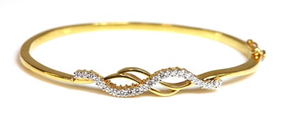 Lot 513 - A high carat gold diamond set hinged bangle