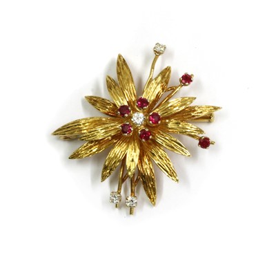 Lot 1076 - An 18ct gold diamond and ruby flowerhead brooch