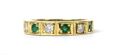 Lot 1195 - An 18ct emerald and diamond half eternity ring