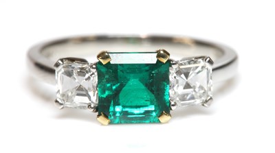 Lot 467 - A platinum and gold three stone emerald and diamond ring, by Pravins, c.2002