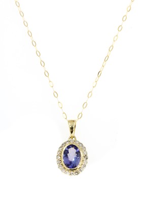 Lot 288 - A gold tanzanite and diamond cluster pendant