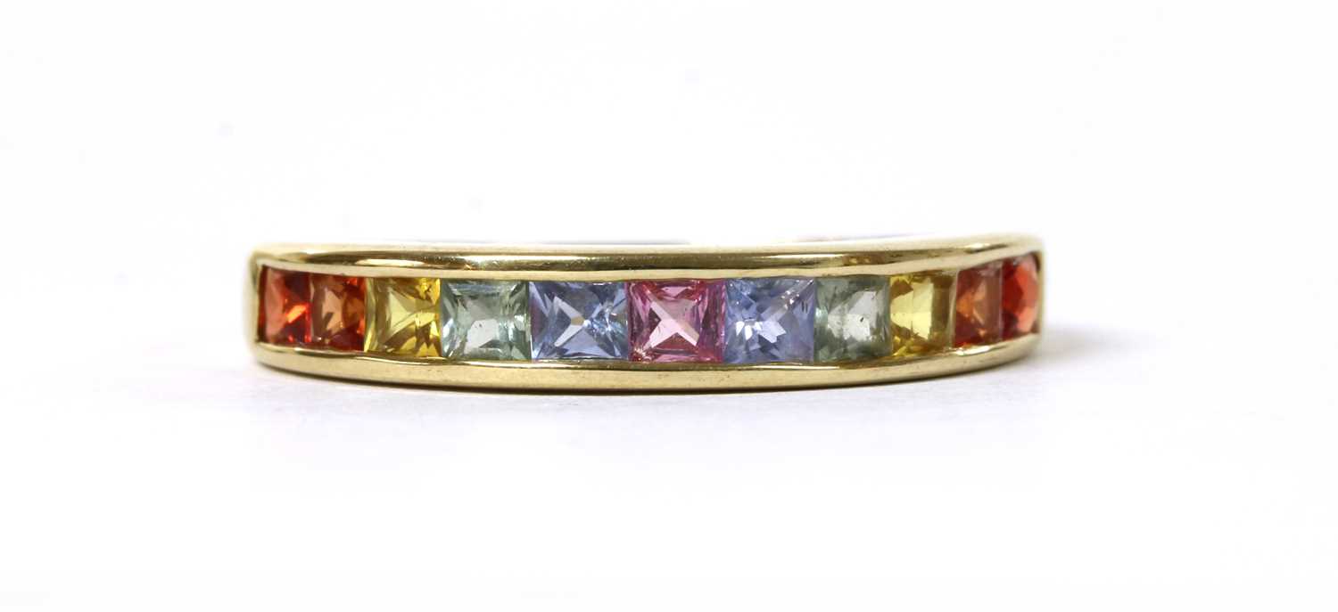 Lot 1197 - A gold rainbow sapphire half eternity ring
