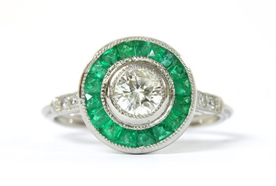 Lot 1185 - A platinum diamond and emerald target cluster ring