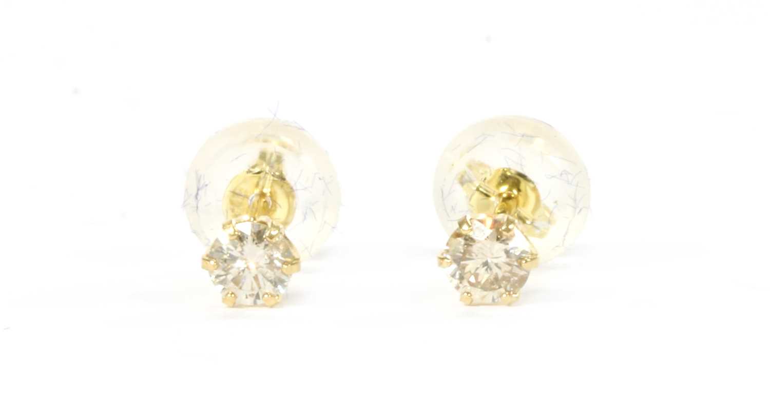 Lot 1092 - A pair of gold single stone diamond stud earrings