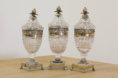 Lot 645 - A set of three cut-glass and silver gilt cups and covers