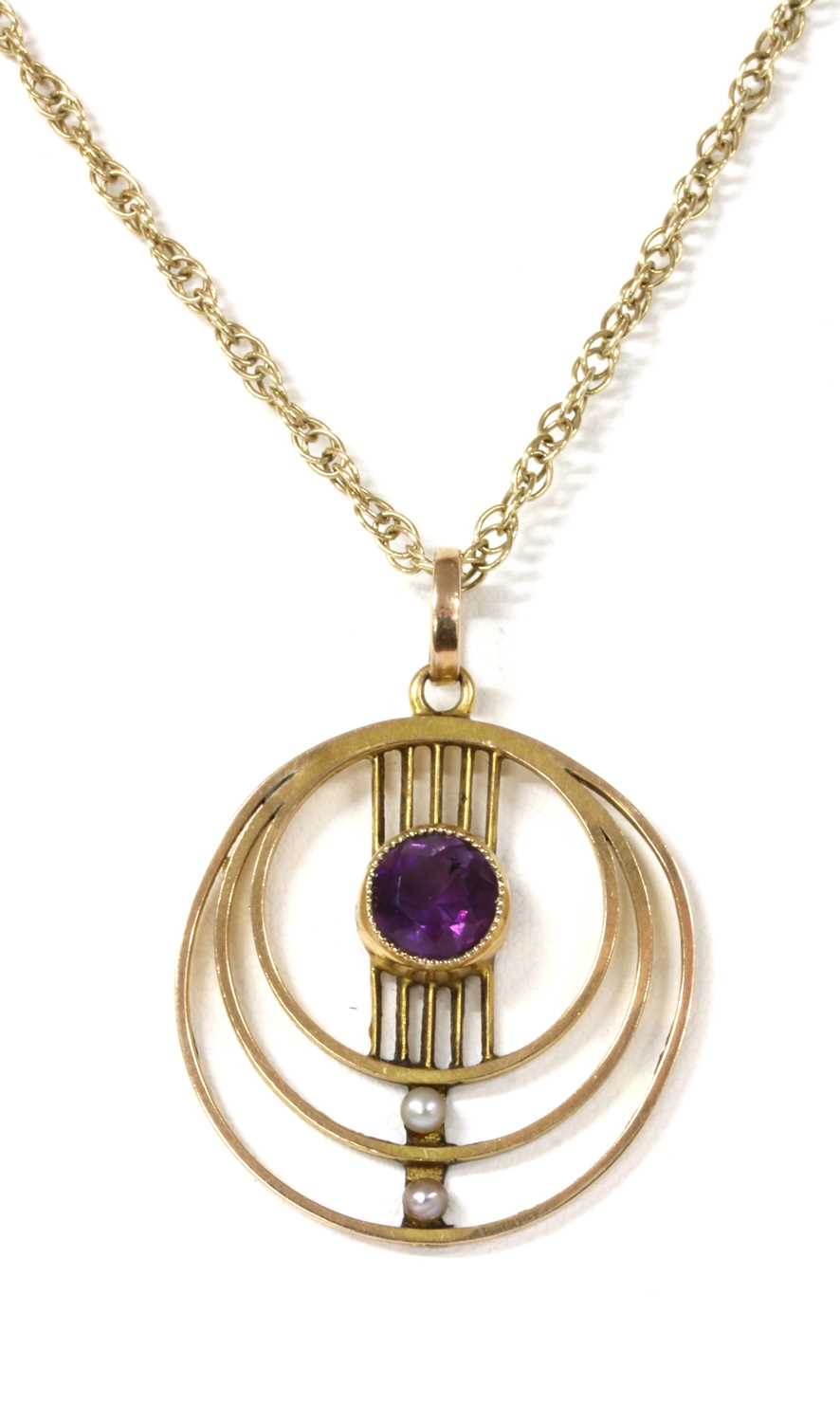 Lot 1051 - An Edwardian gold amethyst and seed pearl pendant