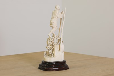 Lot 176 - A Japanese solid carved ivory figure of a man turning a waterwheel