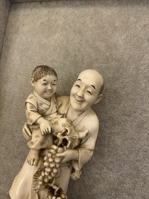 Lot 175 - A Japanese solid carved ivory figure of a man carrying a child