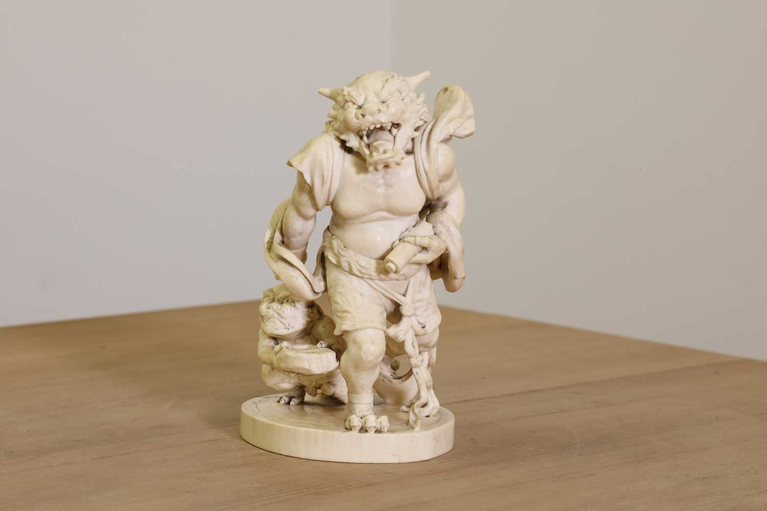 Lot 154 - A Japanese solid carved ivory oni okimono