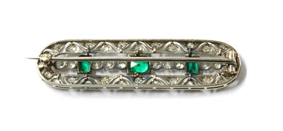 Lot 1061 - An early 20th century white gold emerald and diamond brooch