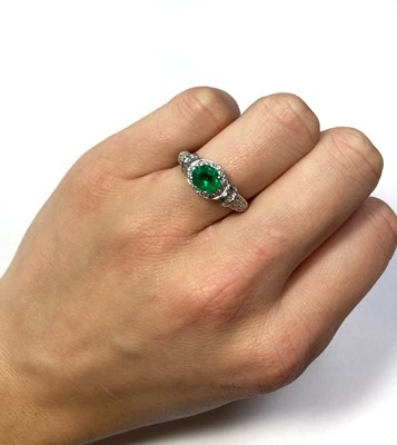 Lot 1186 - A platinum emerald and diamond cluster ring