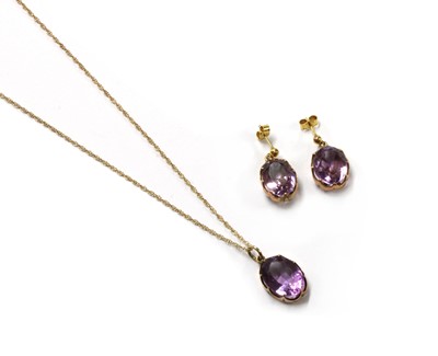 Lot 1250 - A gold single stone amethyst pendant and earrings suite