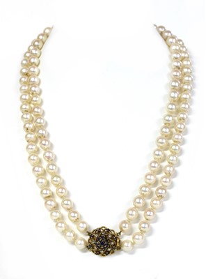 Lot 336 - A two row uniform cultured pearl necklace with sapphire and diamond clasp