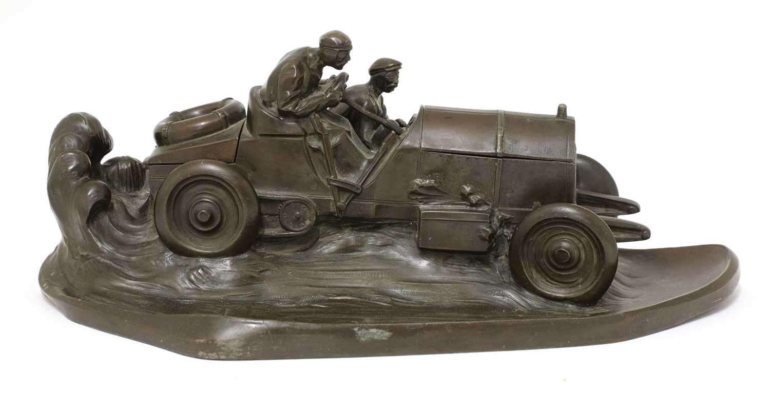 Lot 101 - A Kayser patinated spelter desk stand in the form of a racing car