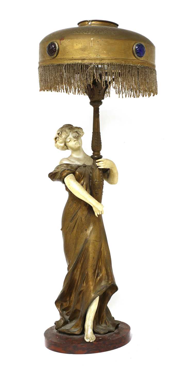 Lot 98 - An Art Nouveau patinated spelter and bisque table lamp