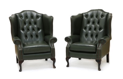 Lot 605 - A pair of green leather upholstered wing back armchairs