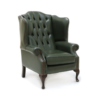 Lot 604 - A green leather upholstered wing back armchair