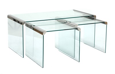 Lot 627 - A nest of three chrome-mounted and glass tables