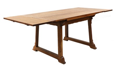 Lot 224 - An Arts and Crafts oak extending dining table