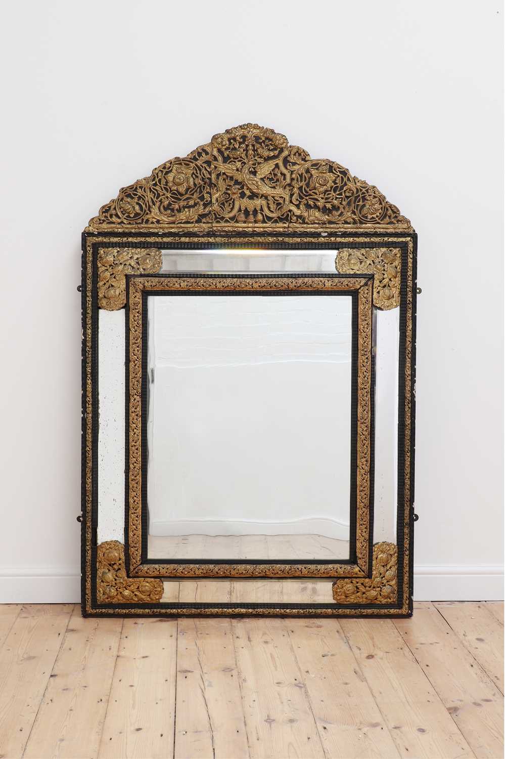Lot 164 - An ebonised walnut and brass wall mirror