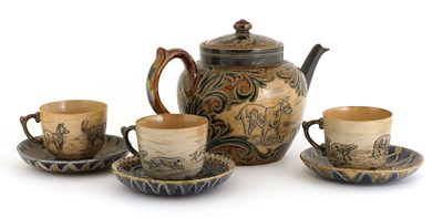 Lot 22 - A Doulton Lambeth teapot and three matched cups and saucers