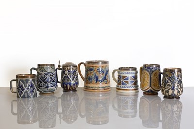 Lot 93 - A collection of seven Doulton Lambeth stoneware mugs and a tankard