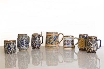 Lot 93 - A collection of seven Doulton Lambeth stoneware mugs and a tankard