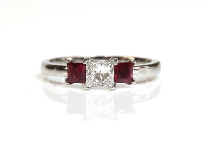 Lot 100 - A platinum three stone diamond and ruby ring