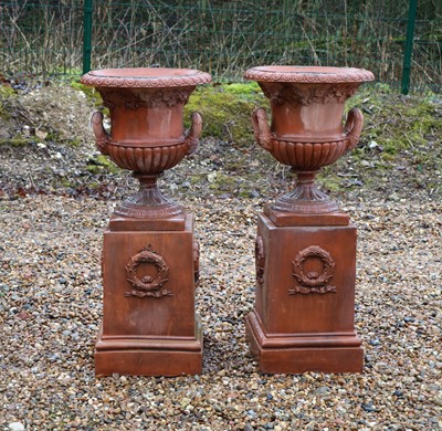 Lot 418 - A pair of faux terracotta urns on stands