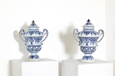 Lot 214 - A pair of delftware blue and white vases and covers
