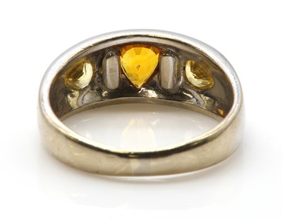 Lot 277 - A white gold three stone orange sapphire and yellow sapphire ring, by Astral Gemstone Talismans
