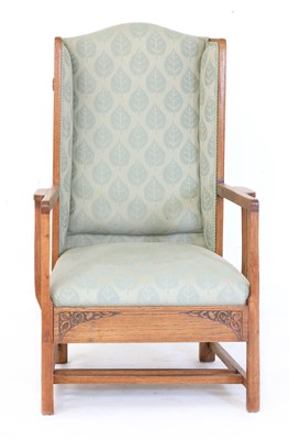 Lot 67 - An Arts and Crafts oak wing-back armchair