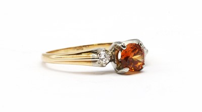 Lot 155 - A gold orange zircon and diamond three stone ring