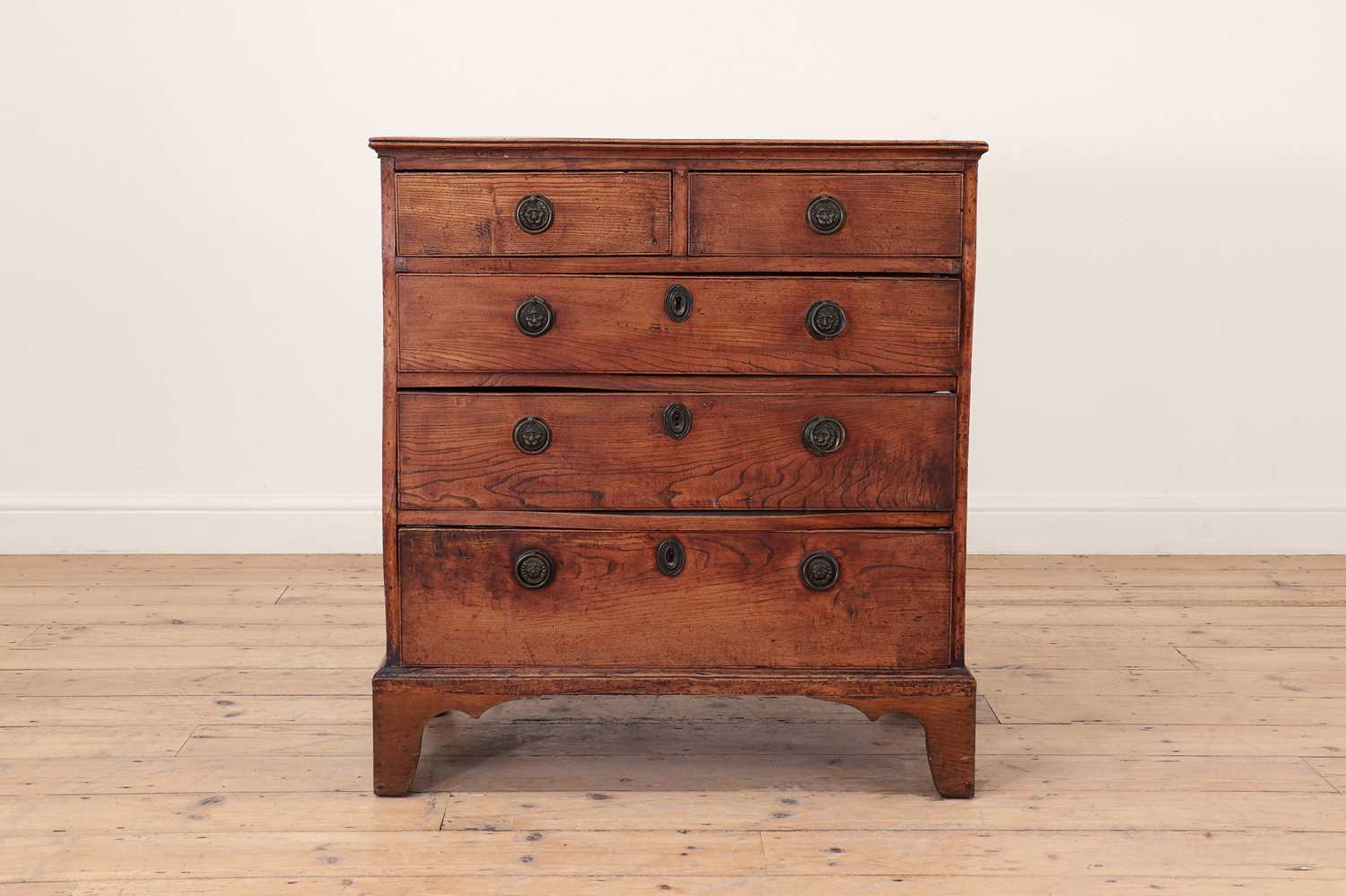 Lot 385 - A George III elm chest of drawers