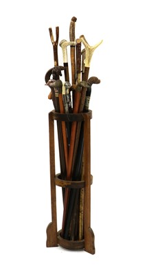 Lot 185 - An oak stick stand containing eighteen various modern walking sticks