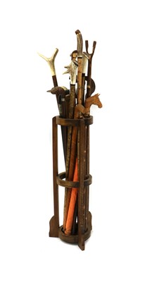 Lot 185 - An oak stick stand containing eighteen various modern walking sticks