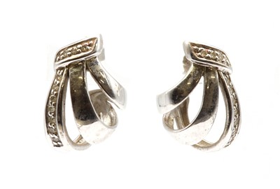 Lot 127 - A pair of 9ct white gold diamond set ribbon spray earrings