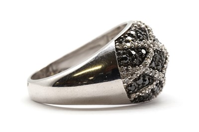 Lot 126 - A 9ct white gold diamond and black diamond bombé ring