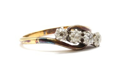Lot 91 - A gold four stone diamond crossover ring