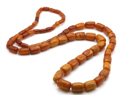 Lot 133 - A single row graduated amber barrel shaped bead necklace